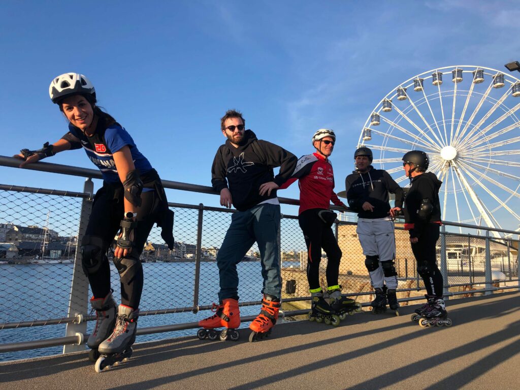 Groupe de 5 personnes en Rollers Randonnées devant une grand roue à Saint Malo