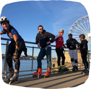 Groupe de cinq personnes en Rollers Randonnées devant une grand roue, Association Rollers Dogues à Saint Malo