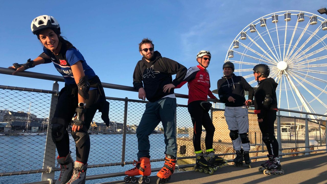 Groupe de 5 personnes en Rollers Randonnées devant une grand roue à Saint Malo